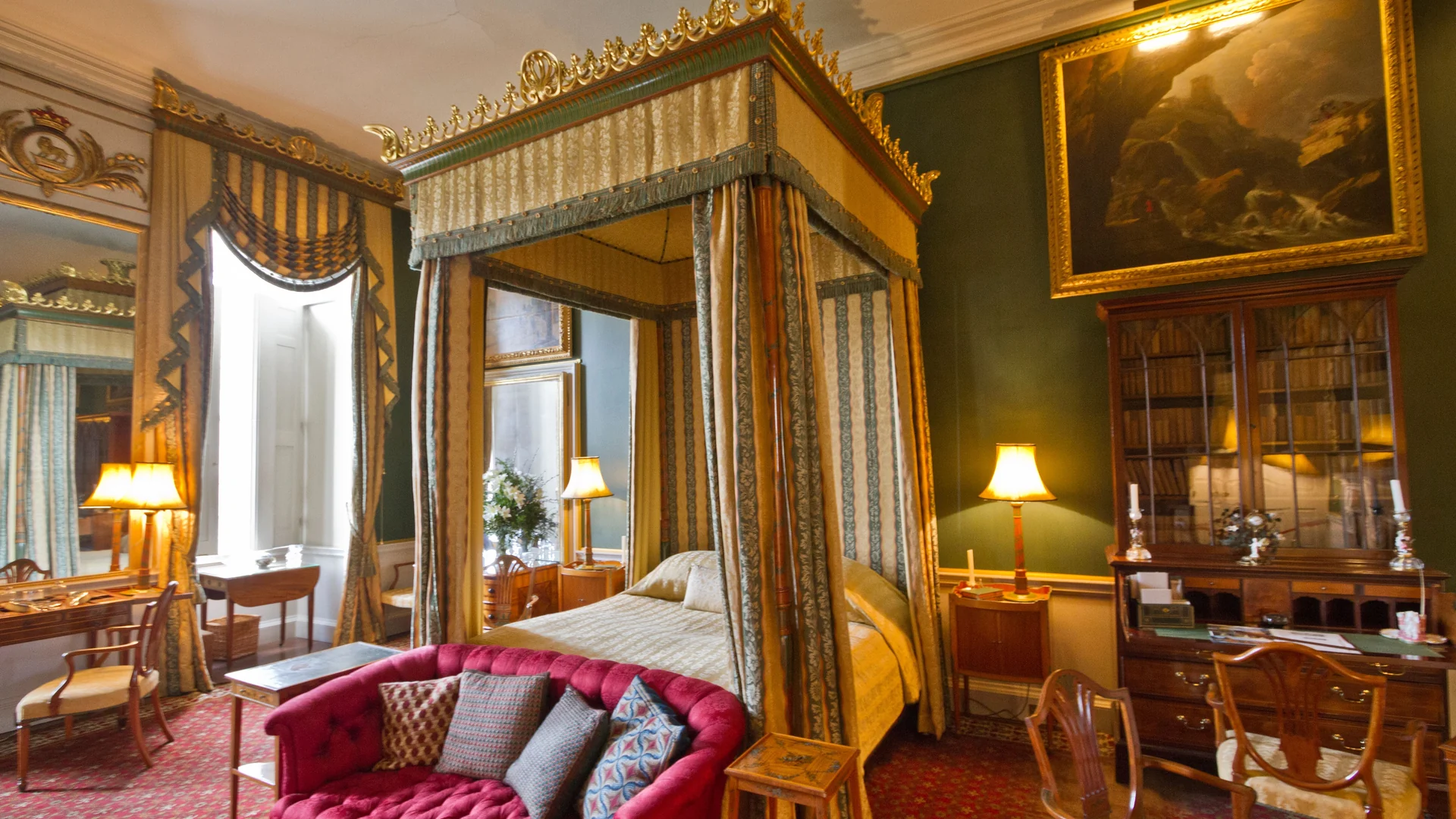 The principal bedroom at Wraycombe House, with a four-poster bed and bookcases