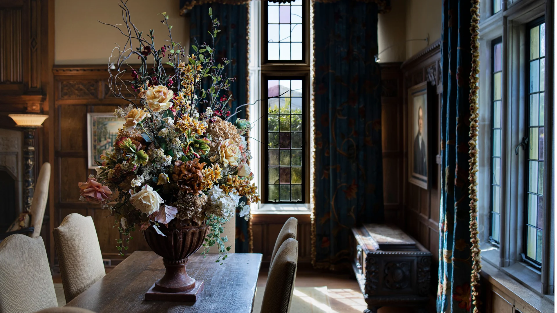 The dining room, with carved oak panelling and a mullioned window with stained glass